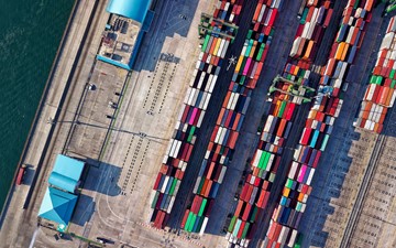 Overhead aerial shot of several stacks of multi-coloured containers stored on a dock