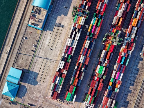Overhead aerial shot of several stacks of multi-coloured containers stored on a dock